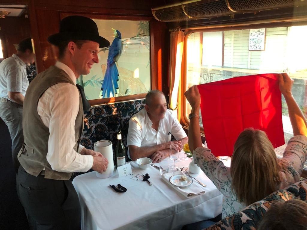 Tischzauberei im Restaurant: eine Gästin hält das rote Tuch